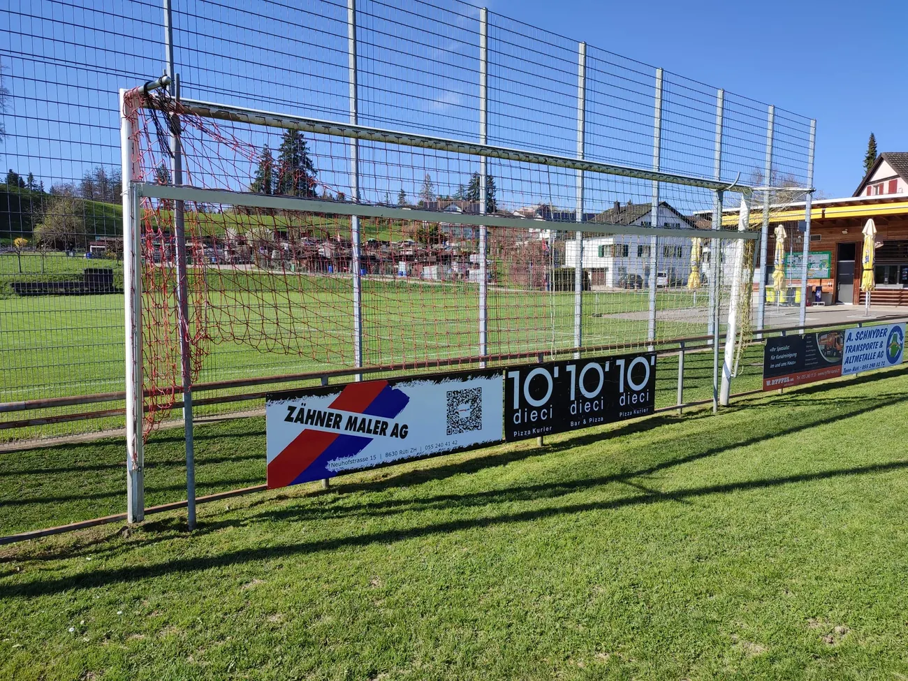 Sponsorenbande der Zähner Maler AG am Fussballplatz des FC Rüti ZH
